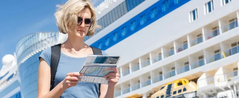 A lady looking at a pamphlet in front of a ferry